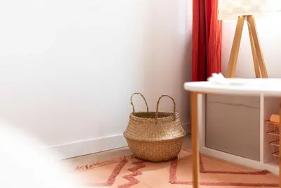 a wicker basket sitting on a floor next to a table at Agréable studio cosy entièrement rénové in Mazamet