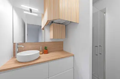 a bathroom with a white sink and a mirror at Agréable studio cosy entièrement rénové in Mazamet