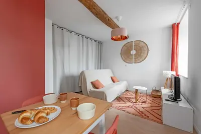 a room with a table with a plate of pastries on it at Agréable studio cosy entièrement rénové in Mazamet
