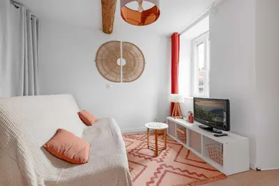 a white room with a bed and a television at Agréable studio cosy entièrement rénové in Mazamet