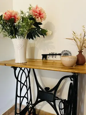 a wooden table with flowers in a vase on it at Les cigales - souplex cosy et calme in Mas-Saintes-Puelles