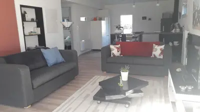 a living room with two couches and a table at L' Abri du Saule in Aussillon