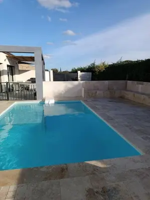 a large blue swimming pool in a backyard at Charmant studio avec piscine in Villemoustaussou