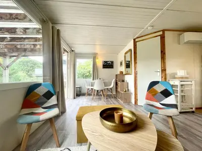 a living room with two chairs and a table at Cosy Chalet au cœur du Sidobre avec Piscine et Spa in Vabre