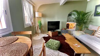 a living room with a tv and a table at L'annexe spa du Tropical Lodge in Narbonne