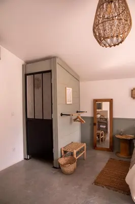 a room with a door and a stool and a mirror at Bessire Chambres & table d'hôtes in Belflou