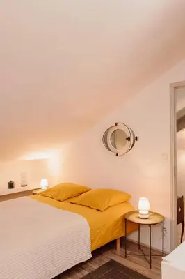 a bedroom with a bed with yellow sheets and a mirror at Terrasse avec vue Domaine Viticole in Sallèles-dʼAude