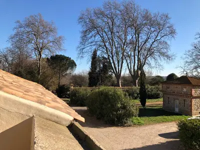 a view of a garden with trees and a building at Terrasse avec vue Domaine Viticole in Sallèles-dʼAude