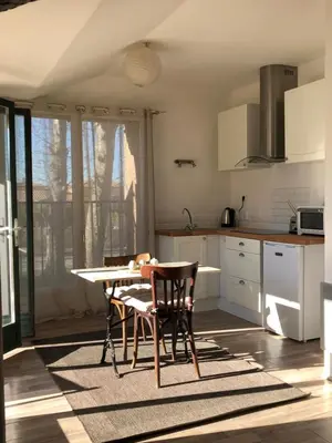 a kitchen with a table and chairs in a room at Terrasse avec vue Domaine Viticole in Sallèles-dʼAude