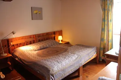 a bedroom with a bed with a wooden headboard at Panorama Gîtes Certes in Gaudiès