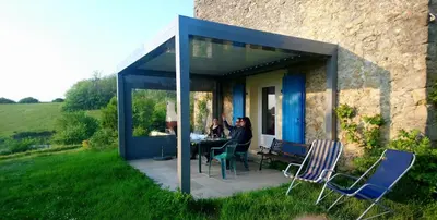 two people sitting at a table on a patio at Panorama Gîtes Certes in Gaudiès