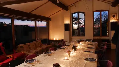 a dining room with a long table with wine glasses at Panorama Gîtes Certes in Gaudiès