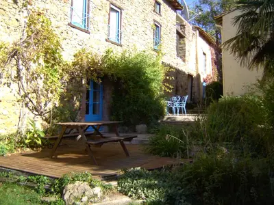 a picnic table on a wooden deck in front of a building at Panorama Gîtes Certes in Gaudiès