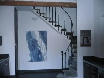 a staircase in a house with a painting on the wall at La Maison Du Ruisseau in Conilhac-Corbières