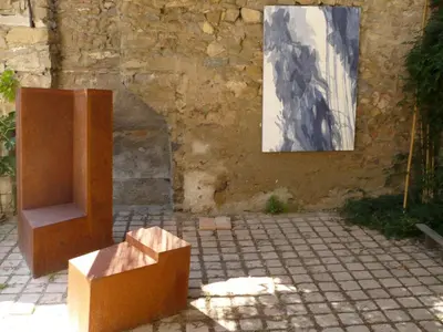 a painting and a box in front of a building at La Maison Du Ruisseau in Conilhac-Corbières