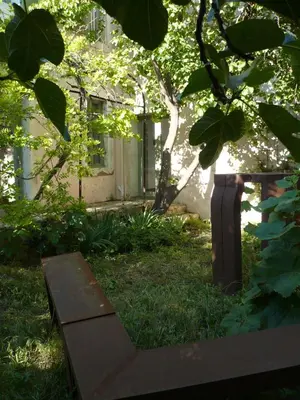 a bench sitting in the grass in front of a building at La Maison Du Ruisseau in Conilhac-Corbières