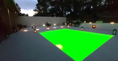 a green pool in a backyard at night at Le Clos FMR - Romain in Malves-en-Minervois
