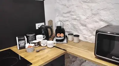 a counter with a coffee maker and cups on it at Les Remparts in Caudiès-de-Fenouillèdes