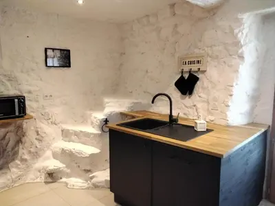 a kitchen with a sink and a stone wall at Les Remparts in Caudiès-de-Fenouillèdes