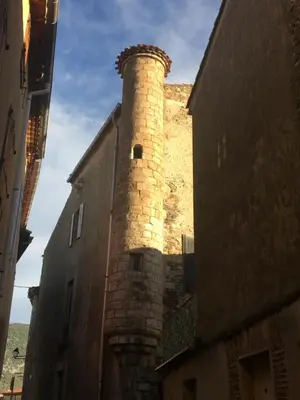 a building with a brick tower on the side of it at Les Remparts in Caudiès-de-Fenouillèdes