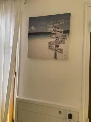 a sign on a wall with a picture of a beach at Maison au cœur du village de Gruissan in Gruissan