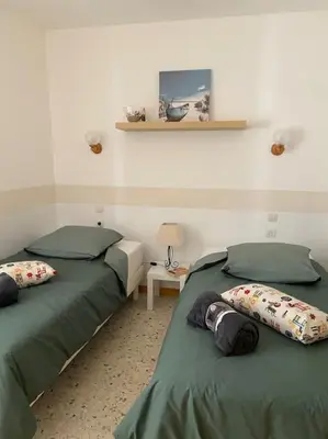 two beds sitting next to each other in a room at Maison au cœur du village de Gruissan in Gruissan