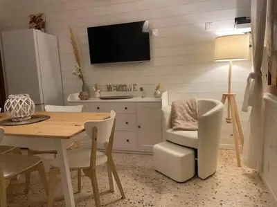 a dining room with a table and a tv at Maison au cœur du village de Gruissan in Gruissan