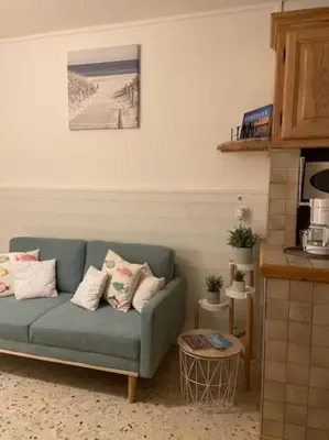 a living room with a blue couch and a table at Maison au cœur du village de Gruissan in Gruissan