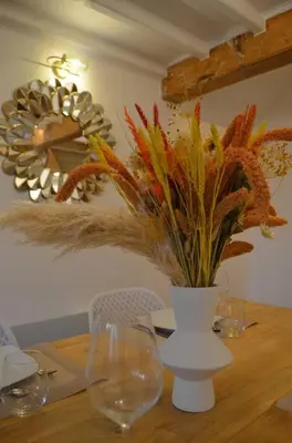 a wooden table with a vase with flowers on it at Charmant appartement - proche château cité in Carcassonne