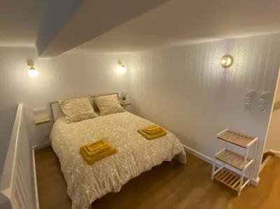 a bedroom with a bed with two yellow towels on it at Charmant appartement - proche château cité in Carcassonne