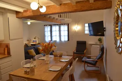 a dining room and living room with a table and chairs at Charmant appartement - proche château cité in Carcassonne