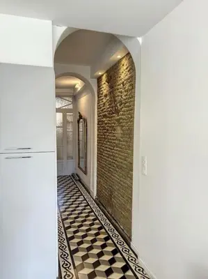 a hallway with a brick wall and a checkered floor at L'écrin Lauragais - Grande maison, 3 chambres 3sdb in Villefranche-de-Lauragais