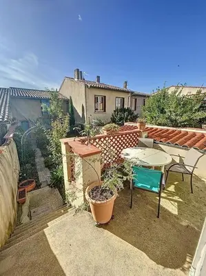 a patio with a table and a table and chairs at L'écrin Lauragais - Grande maison, 3 chambres 3sdb in Villefranche-de-Lauragais