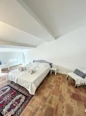 a bedroom with a bed and a chair and a rug at L'écrin Lauragais - Grande maison, 3 chambres 3sdb in Villefranche-de-Lauragais