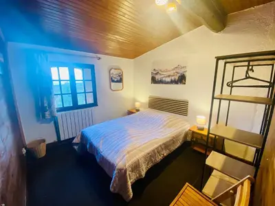a bedroom with a large bed and a window at Maison de campagne à Camps-sur-l'Agly avec vue sur lac in Camps-sur-lʼAgly