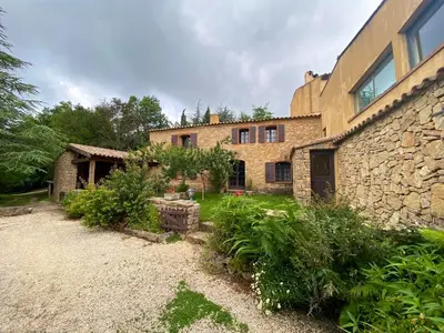 an old stone house with a stone wall at Maison de campagne à Camps-sur-l'Agly avec vue sur lac in Camps-sur-lʼAgly