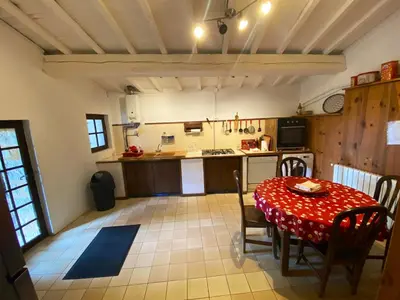 a kitchen with a table with a red table cloth at Maison de campagne à Camps-sur-l'Agly avec vue sur lac in Camps-sur-lʼAgly