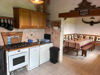 a kitchen with a stove and a sink and a table at Maison confortable au cœur de la nature près de Camps-sur-l'Agly in Camps-sur-lʼAgly