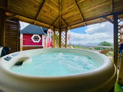a hot tub in a gazebo with a red barn at Maison confortable au cœur de la nature près de Camps-sur-l'Agly in Camps-sur-lʼAgly