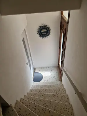 a hallway with stairs and a mirror on the wall at Petite maison au cœur du village in Cessenon