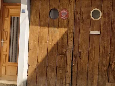 a wooden door with a sign on it at Petite maison au cœur du village in Cessenon
