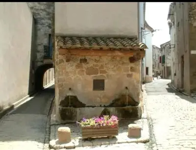 a brick building with a flower box on a street at Petite maison au cœur du village in Cessenon