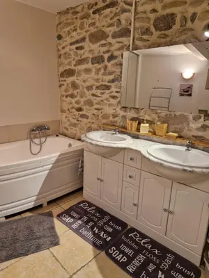 a bathroom with two sinks and a bath tub at Petite maison au cœur du village in Cessenon