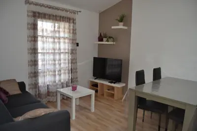 a living room with a couch and a table and a television at Appartement Cité Médiévale Carcassonne in Carcassonne