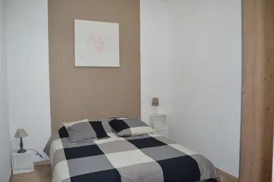 a bedroom with a black and white striped bed at Appartement Cité Médiévale Carcassonne in Carcassonne