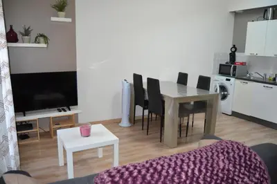 a living room with a table and a kitchen at Appartement Cité Médiévale Carcassonne in Carcassonne