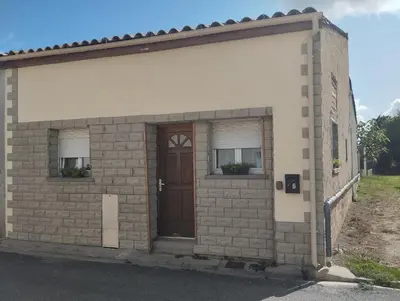 a small brick building with a door and two windows at Repos en campagne in Pexiora