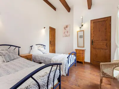 a bedroom with three beds and a wooden floor at Hirondelle - A beautiful rental home in the heart of The Cathar Country in Capestang