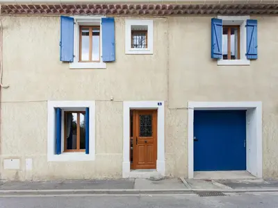 a building with blue windows and a door at Hirondelle - A beautiful rental home in the heart of The Cathar Country in Capestang