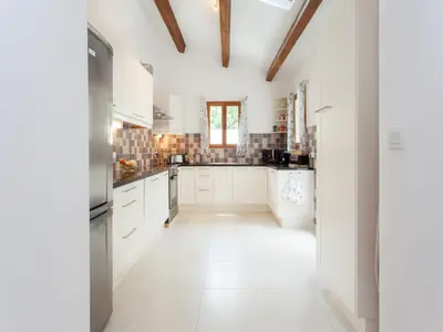 a kitchen with white cabinets and a vaulted ceiling at Hirondelle - A beautiful rental home in the heart of The Cathar Country in Capestang